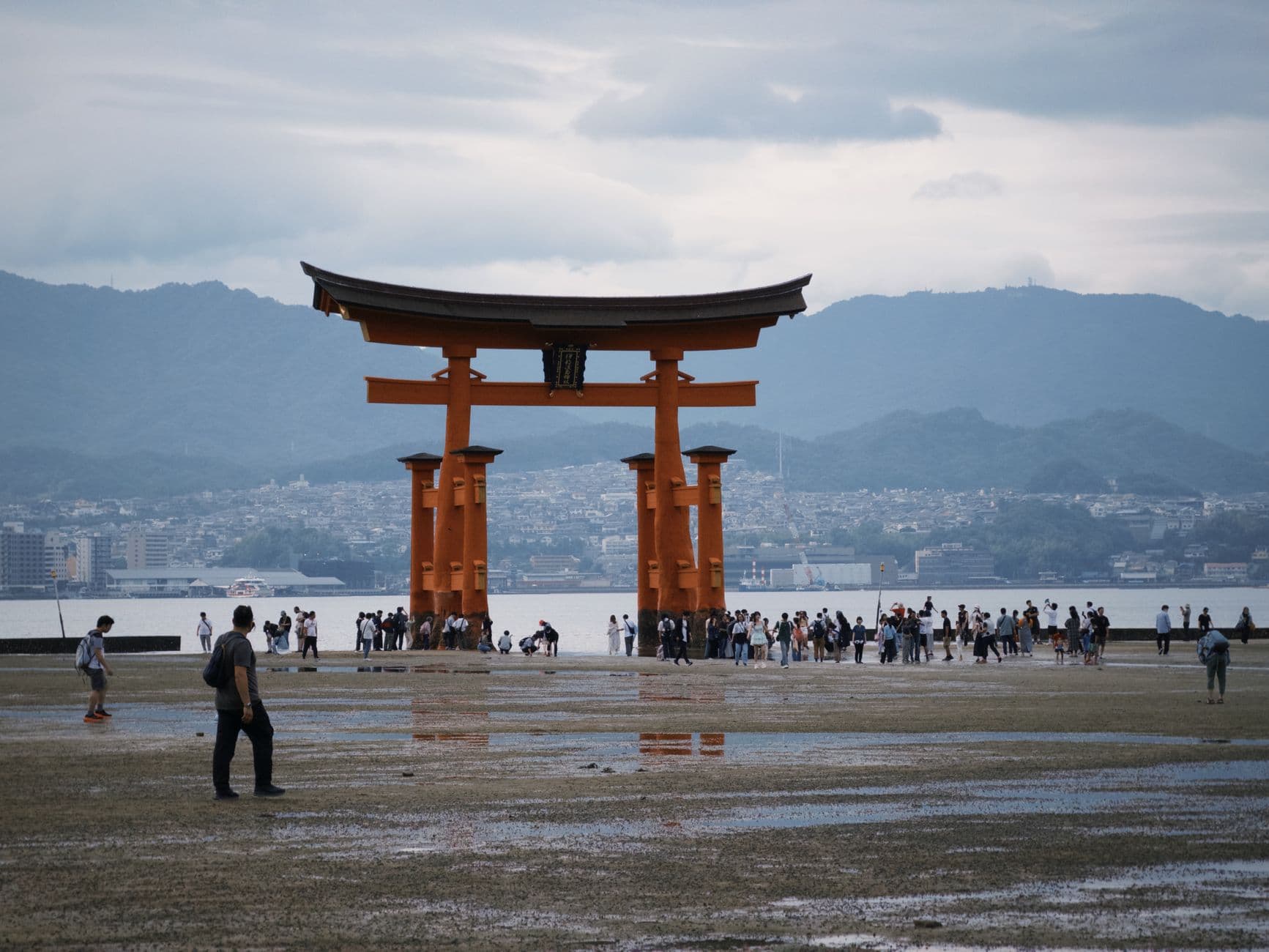 El Gran Torii con marea baja, con gente caminando por la arena